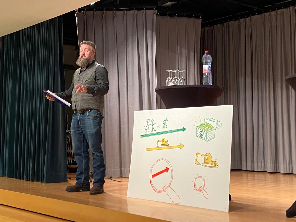 Auf einer Bühne steht ein Mann und erzählt.